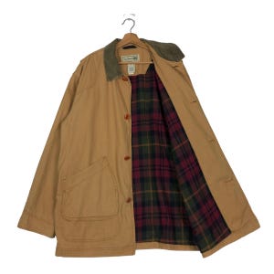 May include: A tan corduroy jacket with a plaid flannel lining. The jacket has a corduroy collar, two front pockets, and a button closure. The label on the jacket reads "L.L.Bean".