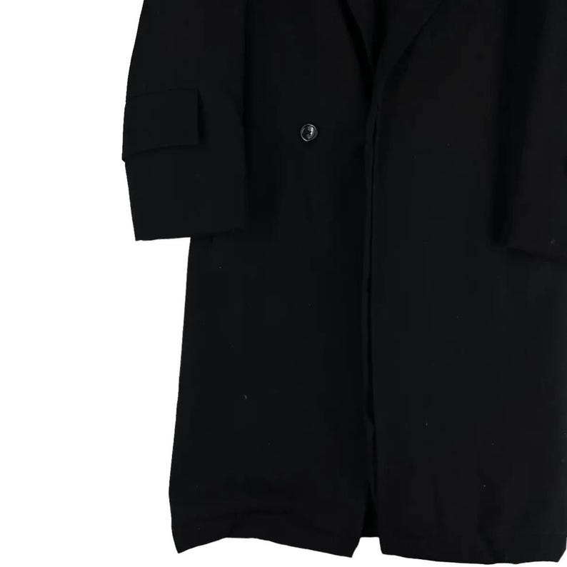 May include: A long, black coat with a classic design. The coat features a notched lapel, a single-breasted closure with a button, and a sleeve with a cuff. The coat is made of a solid, dark fabric.