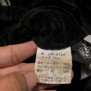 May include: A black and white label with Japanese text and the number 2AB-61.40. The label says "Size Free" and lists the fabric composition: rayon, polyester, and cotton.