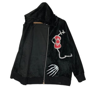 May include: Black velour hooded zip-up jacket with a Hello Kitty graphic on the right side and a skeleton hand graphic on the left side.