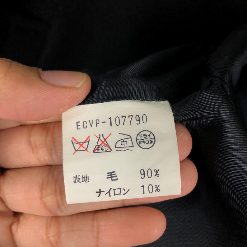 May include: A white tag with the text "ECVP-107790" and Japanese characters. The tag also includes washing symbols and the material composition: 90% wool and 10% nylon.