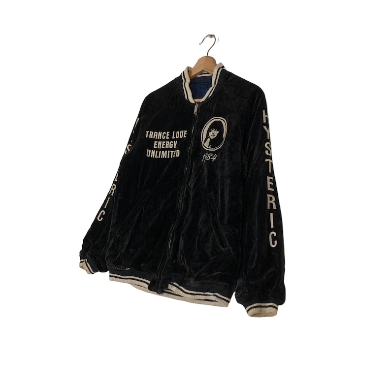 May include: Black velvet bomber jacket with white embroidered lettering that reads "TRANCE LOVE ENERGY UNLIMITED 1984" and "HYSTERIC" on the sleeves.