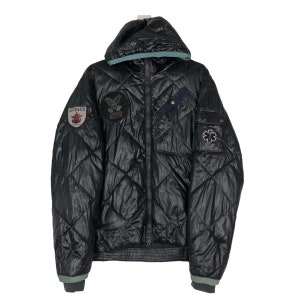 May include: Black quilted jacket with a hood and multiple patches. The jacket features a diamond pattern, a zipper closure, and a green trim on the hood and cuffs. Patches include the "AVIREX" logo and a USCG Rescue emblem.