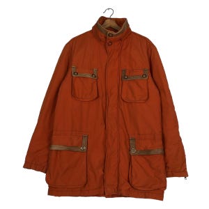 May include: A long-sleeved orange jacket with brown trim and multiple pockets. The jacket has a zipper closure and a high collar.