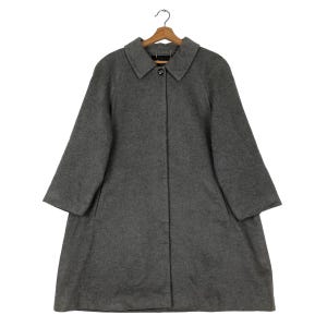 May include: A gray wool coat with a classic collar and a single button closure. The coat has long sleeves and two front pockets. It is hanging on a wooden hanger.