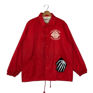 May include: Red collegiate jacket with a white "Collegiate Big John Long Beach Bay" logo and a black skeleton hand patch.