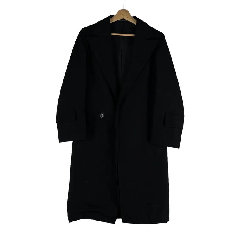 May include: A long, black overcoat with a classic design. The coat features a notched lapel, a single-button closure, and long sleeves with cuff details. It is hanging on a wooden hanger against a white background.