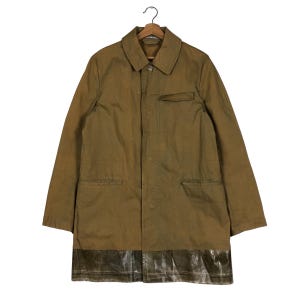 May include: A long-sleeved brown utility jacket with a zip fastening and a contrasting fabric panel at the bottom.