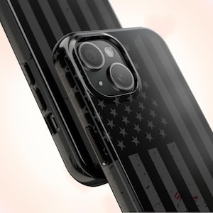May include: Black phone case with a faded American flag design. The case has a raised camera bump and a clear back.
