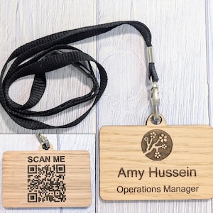 May include: A wooden name tag with a black lanyard. The name tag has a floral design and the text "Amy Hussein, Operations Manager".