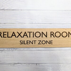 May include: A wooden sign with the text "Relaxation Room. Silent Zone" in black lettering.
