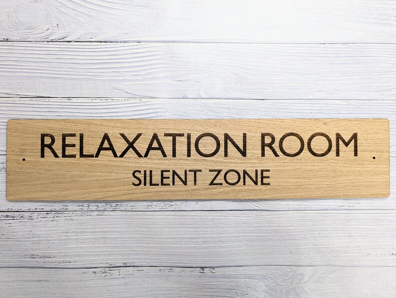 May include: A wooden sign with the text "Relaxation Room. Silent Zone" in black lettering.