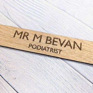 May include: A wooden sign with the text "MR M BEVAN PODIATRIST" engraved on it.