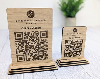 May include: Two wooden signs with a black and white QR code, the text "Cherrygrove Craft" and "Visit Our Website". The larger sign is on a tiered wooden base.