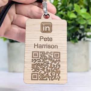 Könnte beinhalten: Ein hölzerner Namensschild mit einem schwarzen Band, mit einem LinkedIn-Logo, dem Namen "Pete Harrison" und einem QR-Code.