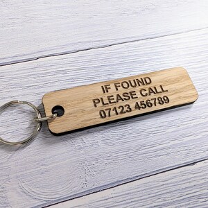 May include: A wooden keychain with the text "IF FOUND PLEASE CALL 07123 456789" engraved on it.