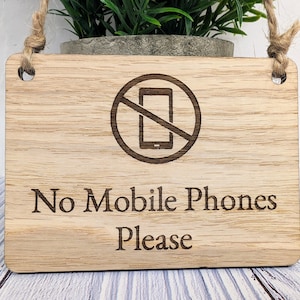 May include: Wooden sign with a no mobile phone symbol and the text "No Mobile Phones Please".