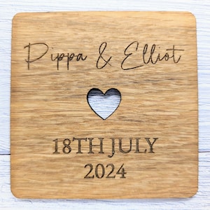 May include: A wooden coaster with a heart cutout and the text "Pippa & Elliot 18TH JULY 2024" engraved on it.