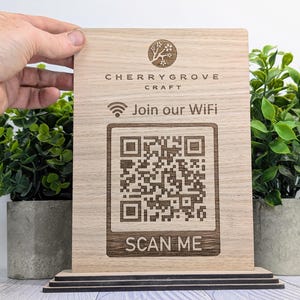 May include: Wooden sign with a cherry blossom logo and the text "Cherrygrove Craft". The sign also includes a WiFi symbol, the text "Join our WiFi", a QR code, and the text "Scan Me".