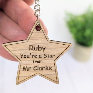 May include: Wooden star-shaped keyring with the text "Ruby You're a Star from Mr Clarke" engraved on it.