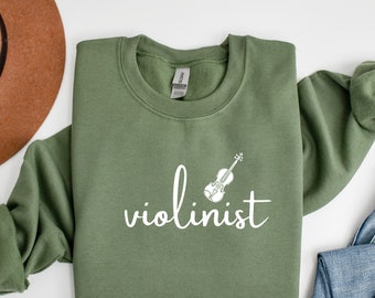 May include: A green sweatshirt with the text "violinist" in white lettering and a small illustration of a violin above the text.