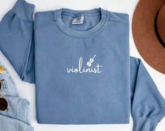 May include: A blue sweatshirt with a white graphic of a violin and the word "violinist" on the front.