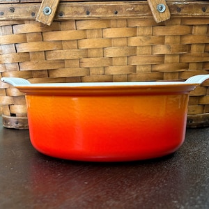 May include: Orange and red enameled cast iron Dutch oven with white rim and handles.