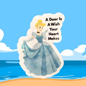 May include: A sticker featuring a cartoon illustration of Cinderella in a blue gown, with the text "A Door Is A Wish Your Heart Makes." The background shows a beach scene with blue water and a light blue sky.
