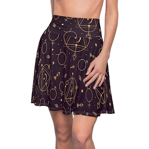 May include: A black skater skirt with a gold geometric pattern of circles, triangles, and stars. The skirt has a high waist and a flared silhouette.