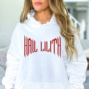 May include: White hooded sweatshirt with the text "HAIL LILITH" in red gothic lettering.