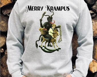 May include: A gray sweatshirt with the text "Merry Krampus" printed on the front. The graphic features a devil-like figure riding a rocking horse with a child on its back.