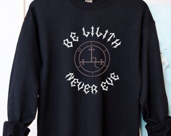 Peut inclure: Sweat-shirt noir avec un imprimé graphique blanc qui dit "Be Lilith Never Eve" avec un sceau au centre.