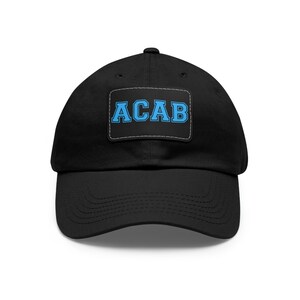May include: Black baseball cap with a curved peak. A rectangular patch on the front displays the letters "ACAB" in light blue, outlined in a darker blue, against a black background.