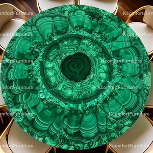 Op de afbeelding: Een ronde, groene malachiet tafelblad met een uniek patroon van wervelende lijnen en concentrische cirkels. De tafel wordt omringd door verschillende witte en houten stoelen, waardoor een moderne eethoek ontstaat. De diameter van de tafel is ongeveer 122 cm.