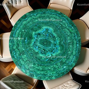 Op de afbeelding: Een ronde tafel met een levendig malachietblad, met concentrische patronen van groene en blauwe tinten. De tafel is omringd door crèmekleurige stoelen, wat een luxe en stijlvolle eet- of woonkameromgeving creëert. De tekst "KcomfortFurniture" is zichtbaar.