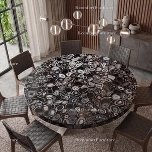 May include: A circular dining table with a black and white patterned surface, encircled by six chairs with woven backs. The chairs have wooden frames. The room has a modern design with a large window and a chandelier.