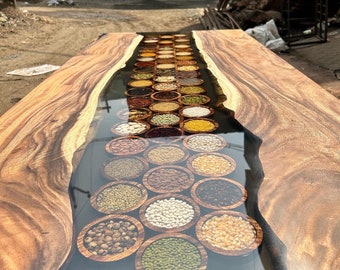 Puede incluir: Una mesa de madera con un río de resina epoxi transparente que recorre el centro. La resina contiene una variedad de diferentes tipos de frijoles y granos.