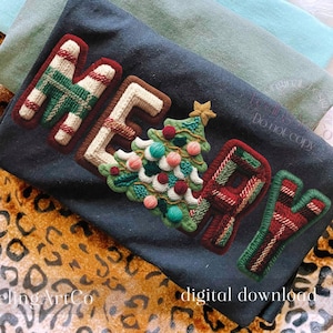 May include: A navy blue t-shirt with the word "MERRY" appliqued in a festive design. The letters are in a plaid pattern with a Christmas tree in the center. The background includes folded fabric and a leopard print.