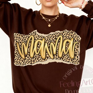 May include: A brown sweatshirt with the word "Mama" in gold script. The word is set against a leopard print background with a torn paper effect. The sweatshirt is a crew neck style.