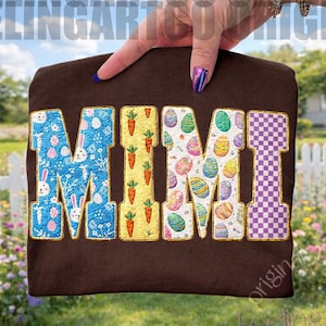 Könnte beinhalten: Ein braunes T-Shirt mit dem Wort "MIMI" in bunten, gemusterten Buchstaben. Das "M" zeigt ein blaues Osterei- und Hasenmuster, das "I" orange Karotten und die anderen "M" und "I" Osterei- und Schachbrettmuster.