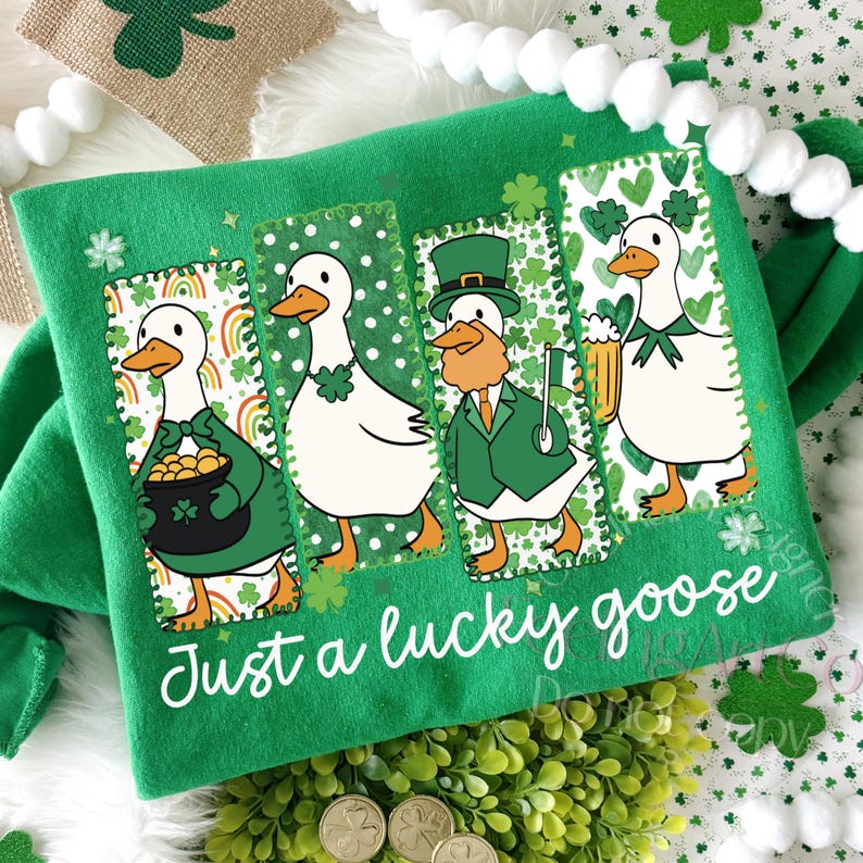 May include: Green St. Patrick's Day themed shirt with the text "Just a lucky goose". The shirt features four cartoon geese in green outfits, each in a different pose. One goose holds a pot of gold, another has a shamrock necklace, and another holds a beer.