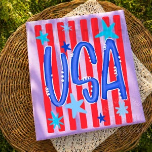 May include: A patriotic design with the word "USA" in blue, outlined in white, on a lavender background with red stripes. Turquoise stars are scattered across the design, creating a festive and celebratory atmosphere.