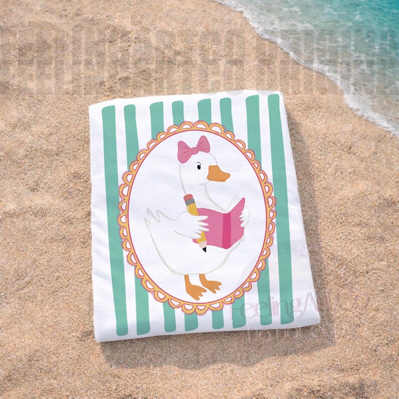 May include: White beach towel with vertical mint green stripes. The towel features a cartoon goose wearing a pink bow and reading a pink book with a pencil. The goose is inside an oval frame with a scalloped edge. The towel is on a sandy beach.