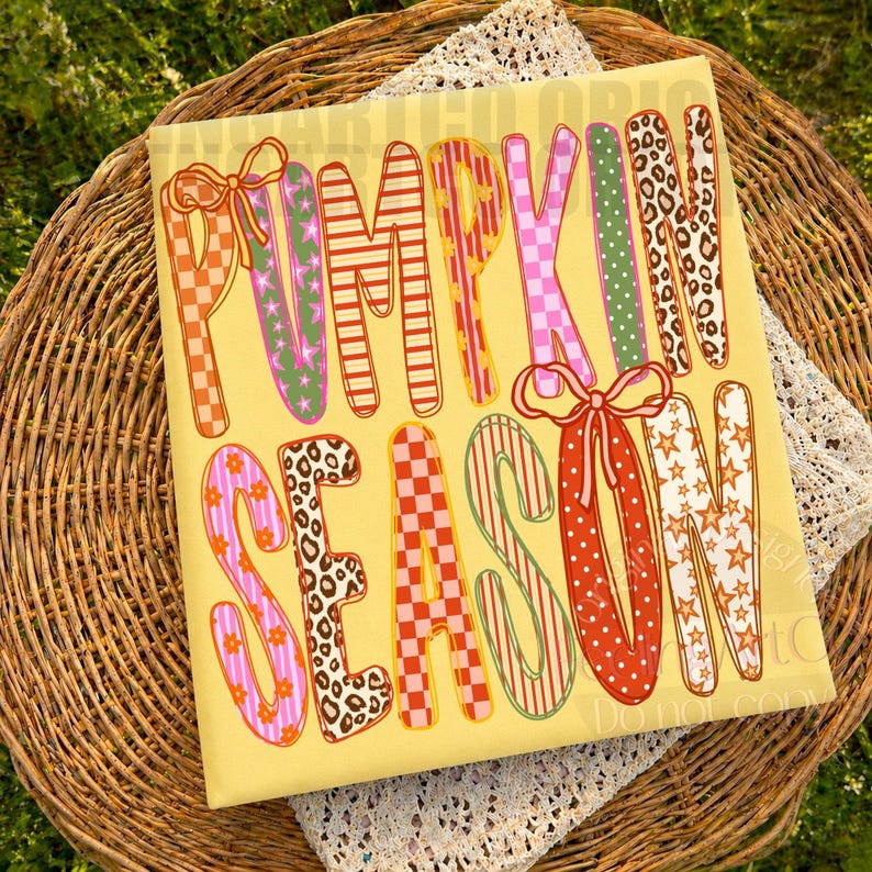 May include: A square yellow sign featuring the text PUMPKIN SEASON in large, colorful, patterned letters. The letters display various designs including orange and white checkers, green stars, red stripes, pink flowers, and brown leopard print.