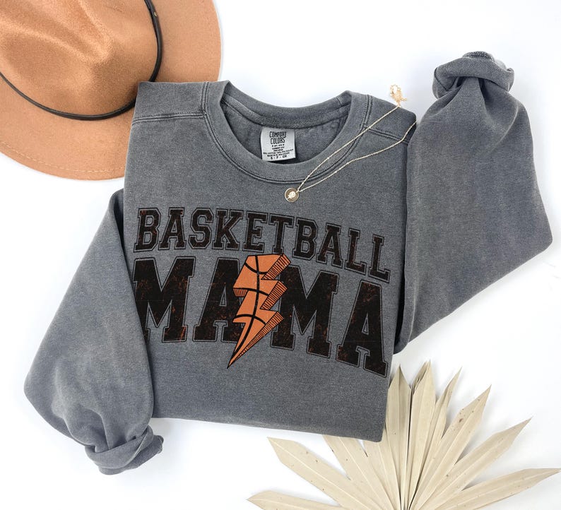 May include: Gray sweatshirt with a distressed graphic print that says "Basketball Mama" with a basketball and lightning bolt design.