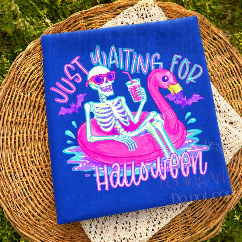 Peut inclure: Un t-shirt bleu avec un motif sur le th&egrave;me d'Halloween. Le design pr&eacute;sente un squelette portant des lunettes de soleil flottant sur un flotteur de flamant rose, tenant une boisson. Le texte dit "Just Waiting for Halloween."