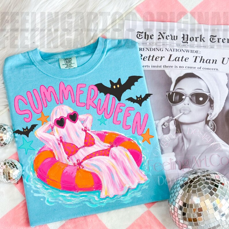 K&ouml;nnte beinhalten: Hellblaues T-Shirt mit dem pinkfarbenen Schriftzug "SUMMERWEEN", das einen Geist in Bikini und Sonnenbrille auf einem Schwimmring zeigt. Enth&auml;lt Fledermaus- und Sternengrafiken. Ein Zeitungsausschnitt und eine Discokugel im Hintergrund.