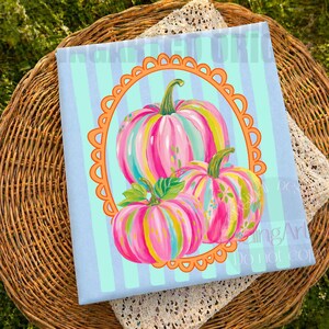 K&ouml;nnte beinhalten: Ein hellblauer Stoff mit vertikalen Streifen zeigt ein dekoratives Design von drei bunten K&uuml;rbissen. Die K&uuml;rbisse sind mit rosa, gelben und gr&uuml;nen Streifen bemalt und in einem orangefarbenen, geschwungenen Rahmen angeordnet. Das Design befindet sich auf einem hellblauen Hintergrund.
