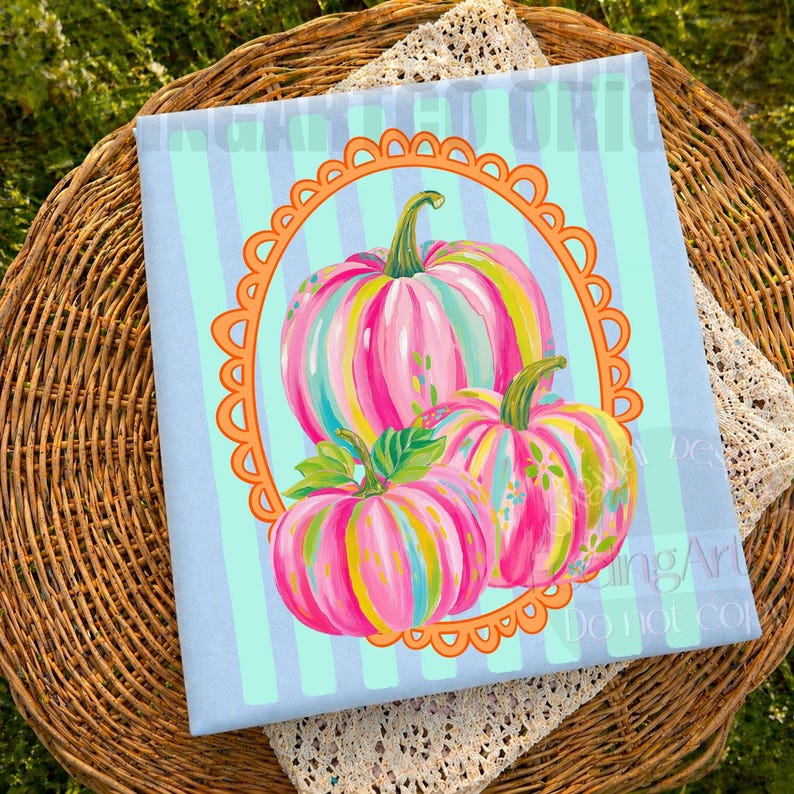 K&ouml;nnte beinhalten: Ein hellblauer Stoff mit vertikalen Streifen zeigt ein dekoratives Design von drei bunten K&uuml;rbissen. Die K&uuml;rbisse sind mit rosa, gelben und gr&uuml;nen Streifen bemalt und in einem orangefarbenen, geschwungenen Rahmen angeordnet. Das Design befindet sich auf einem hellblauen Hintergrund.