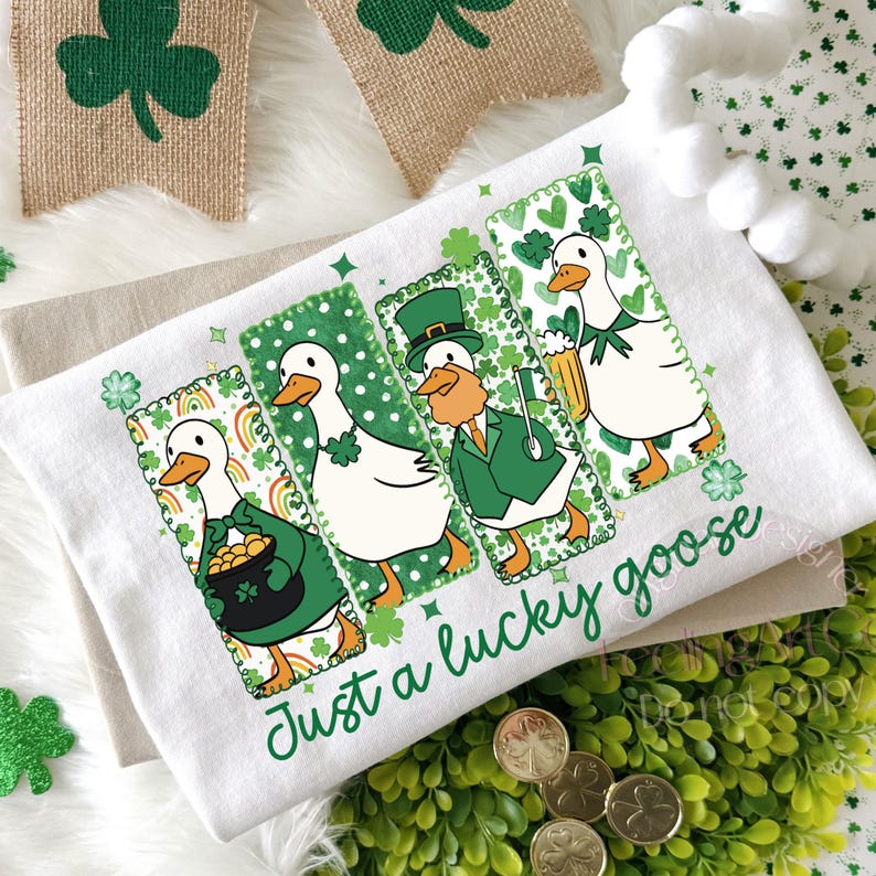 May include: White St. Patrick's Day kitchen towel featuring four cartoon geese in green outfits, each with a different St. Patrick's Day theme. The towel has the text "Just a lucky goose" in green script.